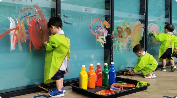 Child painting with his hands at Apple Tree Playhouse childcare in Yishun