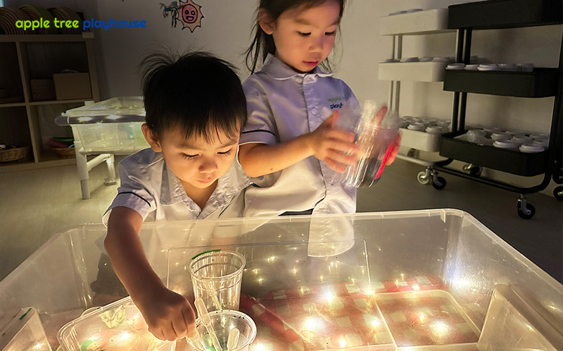 Children develop fine motor skills and coordination through light play at Apple Tree Playhouse.