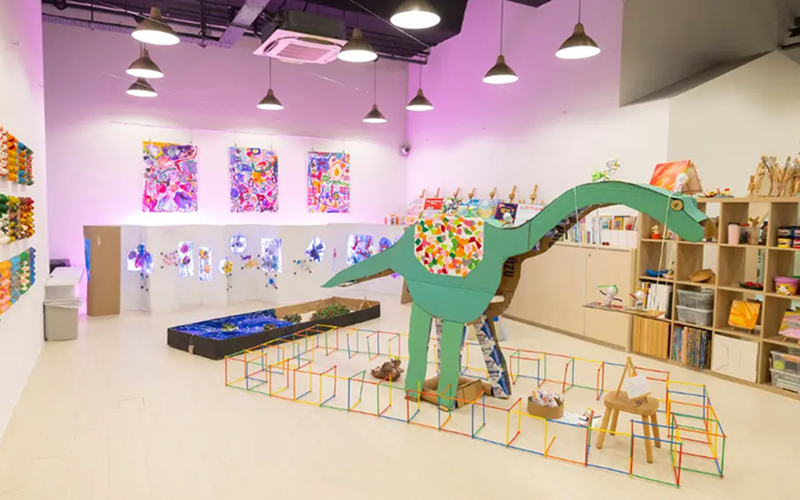 Creative-preschool-play-space-with-cardboard-dinosaur-art-installation